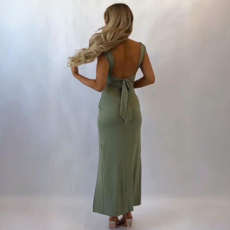 Woman wearing a green dress with a backless design on a white background