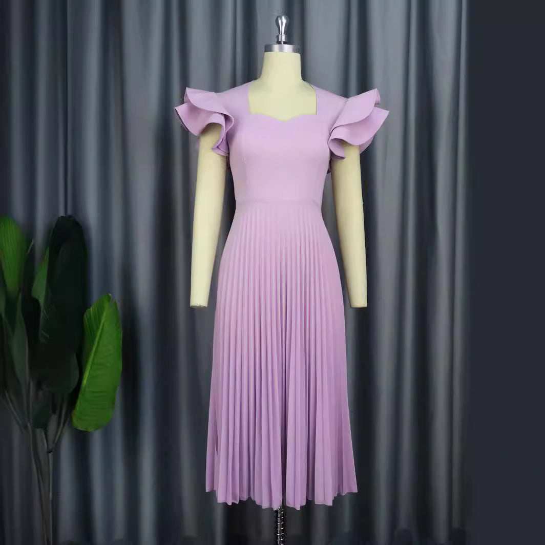 Purple pleated dress on a mannequin against a gray curtain background
