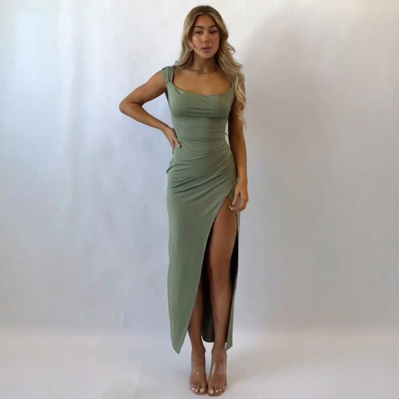 Woman wearing a green dress with a high slit on a white background