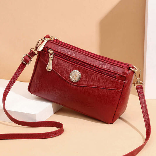 Red handbag with gold accents on a beige background