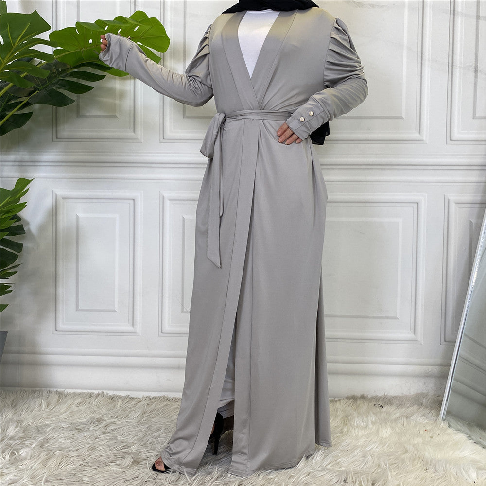 Gray long-sleeve dress with a belt on a white paneled wall background