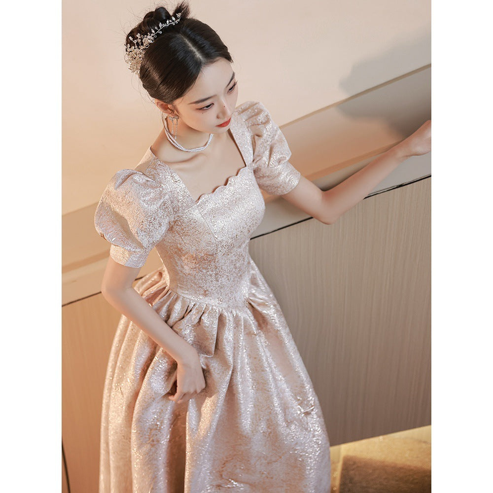 Woman in a sparkling dress posing against a neutral background