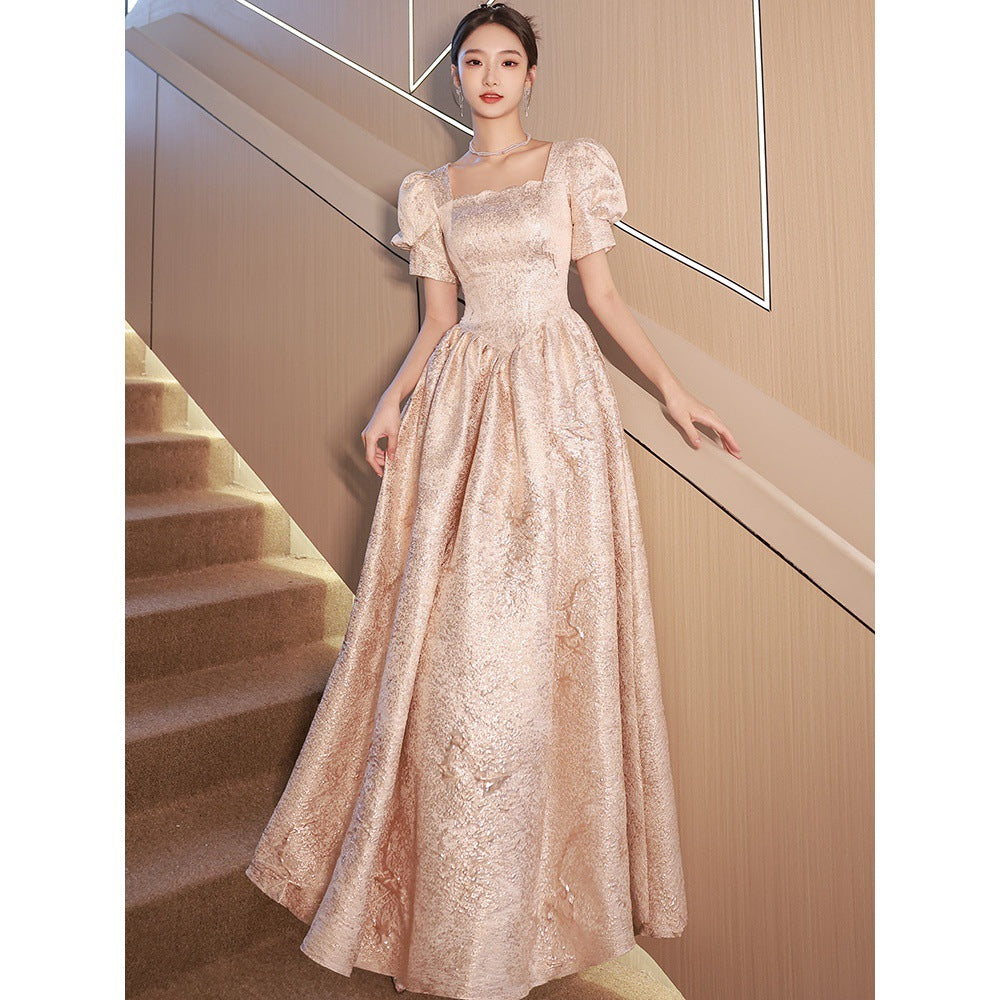 Woman in a elegant lace dress standing in a staircase.