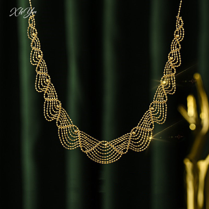Gold necklace on a dark green curtain background