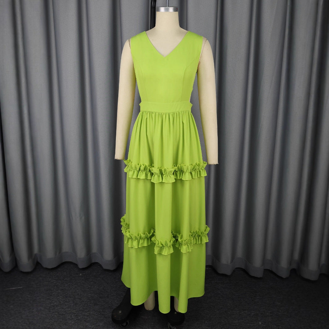 Green dress on a mannequin against a gray curtain background