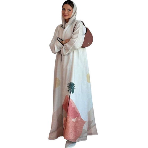 Woman wearing a long, light-colored Modest Floral Style Abaya with a palm tree design on a white background