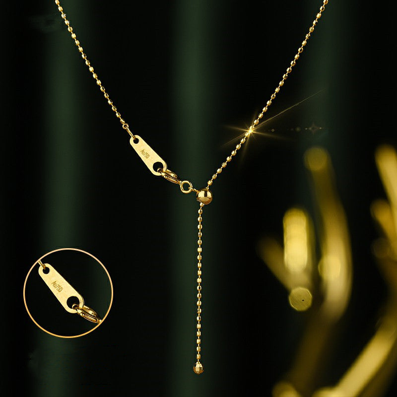 Gold necklace with a pendant on a dark background