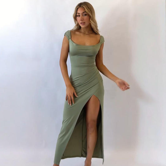 Woman wearing a green dress with a slit on a white background