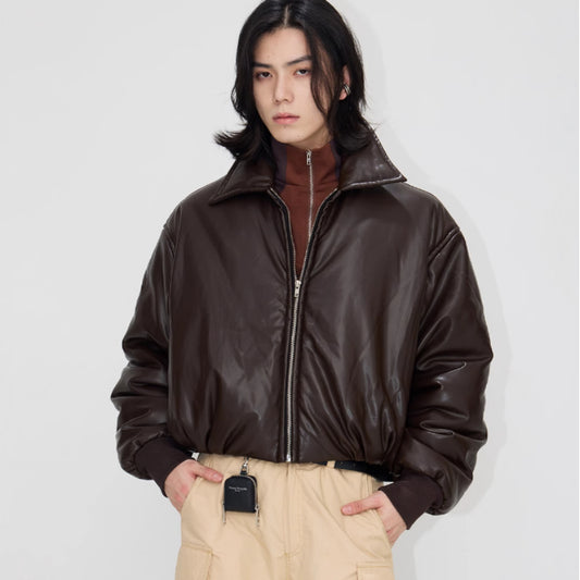 Person wearing a brown leather jacket on a plain background