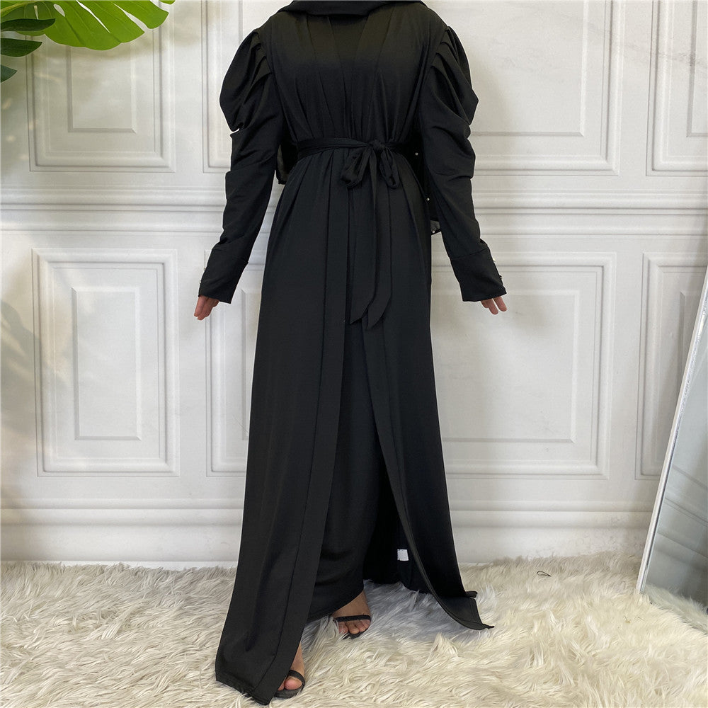 Person wearing a black dress against a white paneled wall.